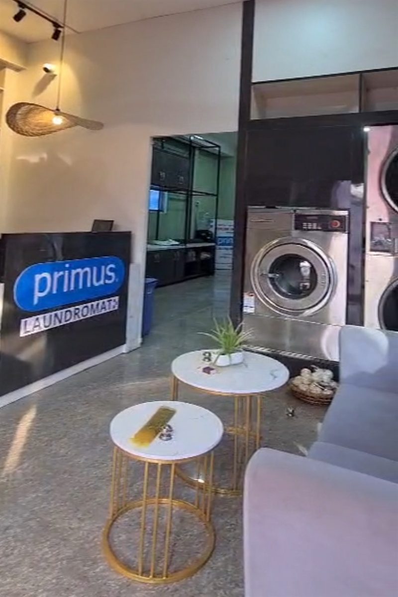Front view of Primus Laundromat store in Imphal with signage and customers.